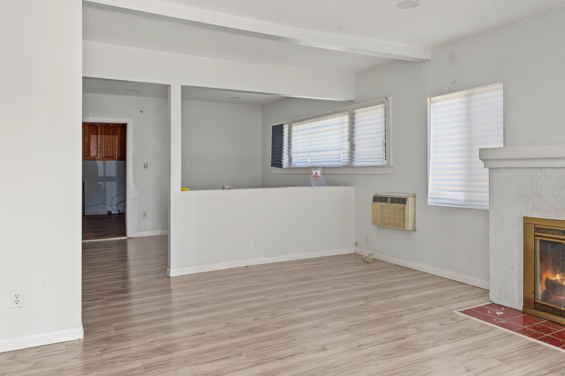 Living room with fireplace and an opening toward the dining area at 2829 S Rimpau